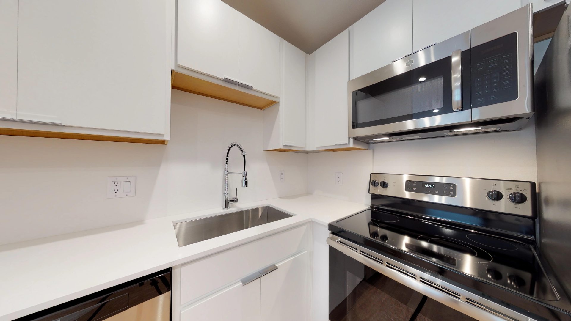 a kitchen with stainless steel appliances and white cabinets at The Flamingo