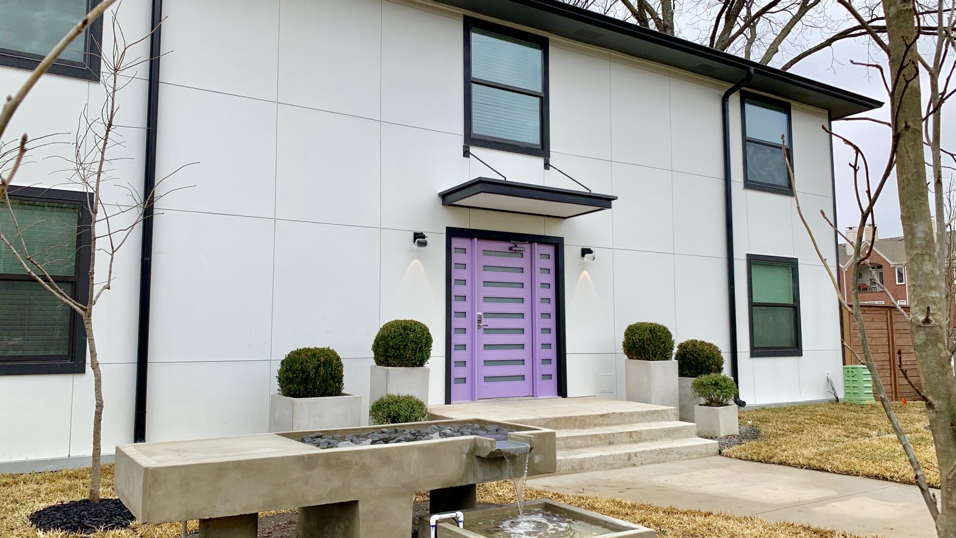 a purple door and a fountain in front of a house at The Flamingo