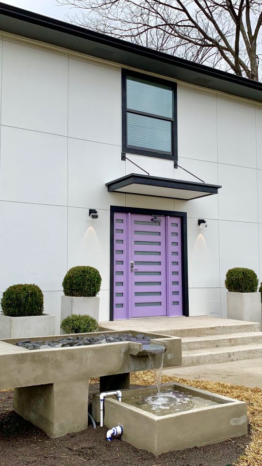 a purple door and a fountain in front of a house at The Flamingo