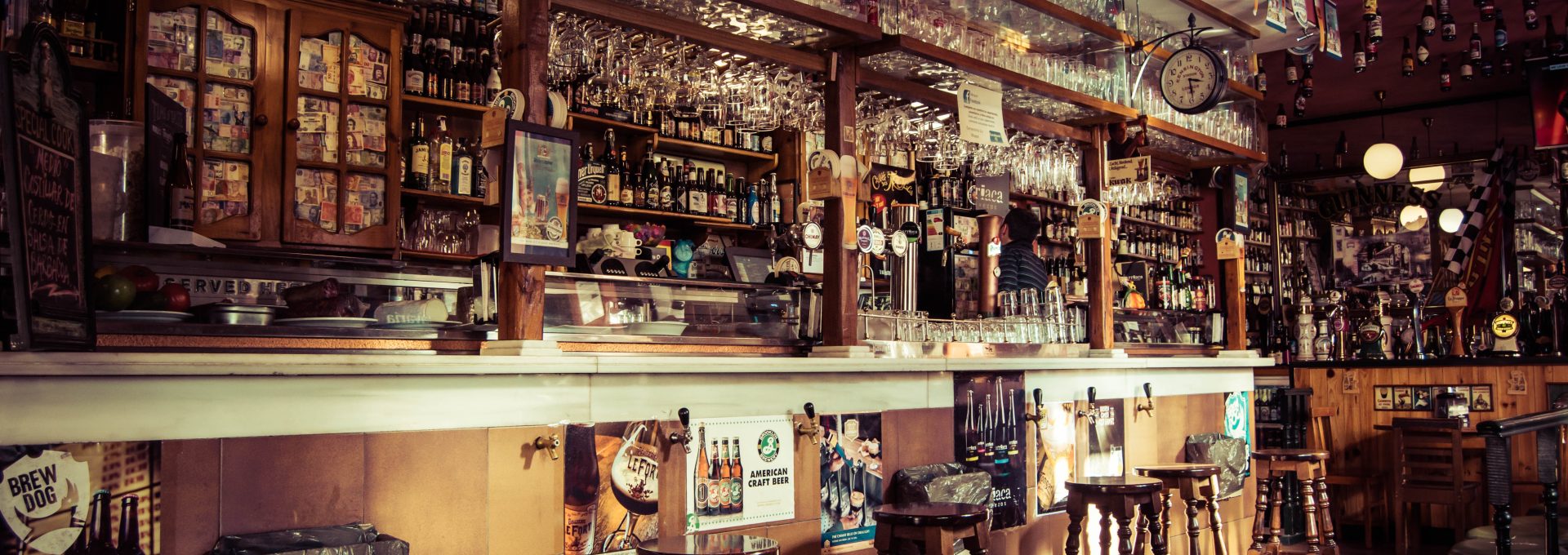 a bar with many stools and a long bar at The Flamingo