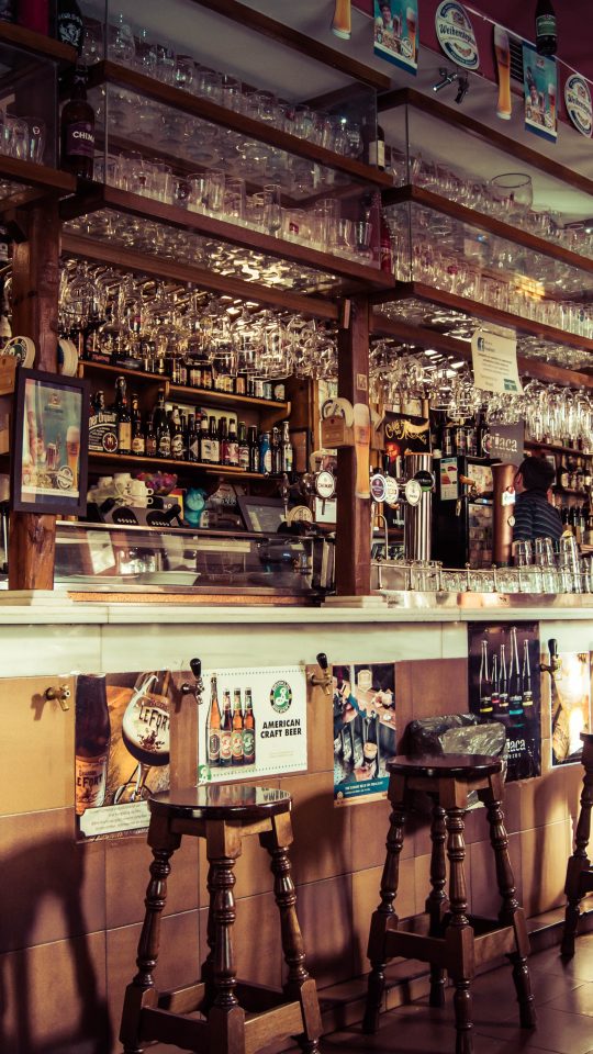 a bar with many stools and a long bar at The Flamingo