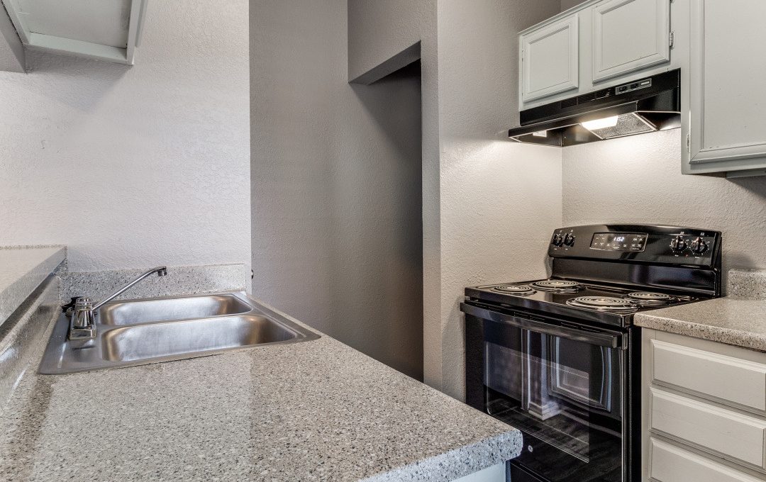 a kitchen with a stove, sink and microwave at The Huntington Brook
