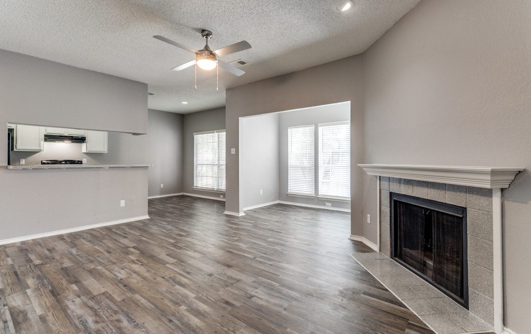 empty living room with hardwood floors and ceiling fan at The Huntington Brook