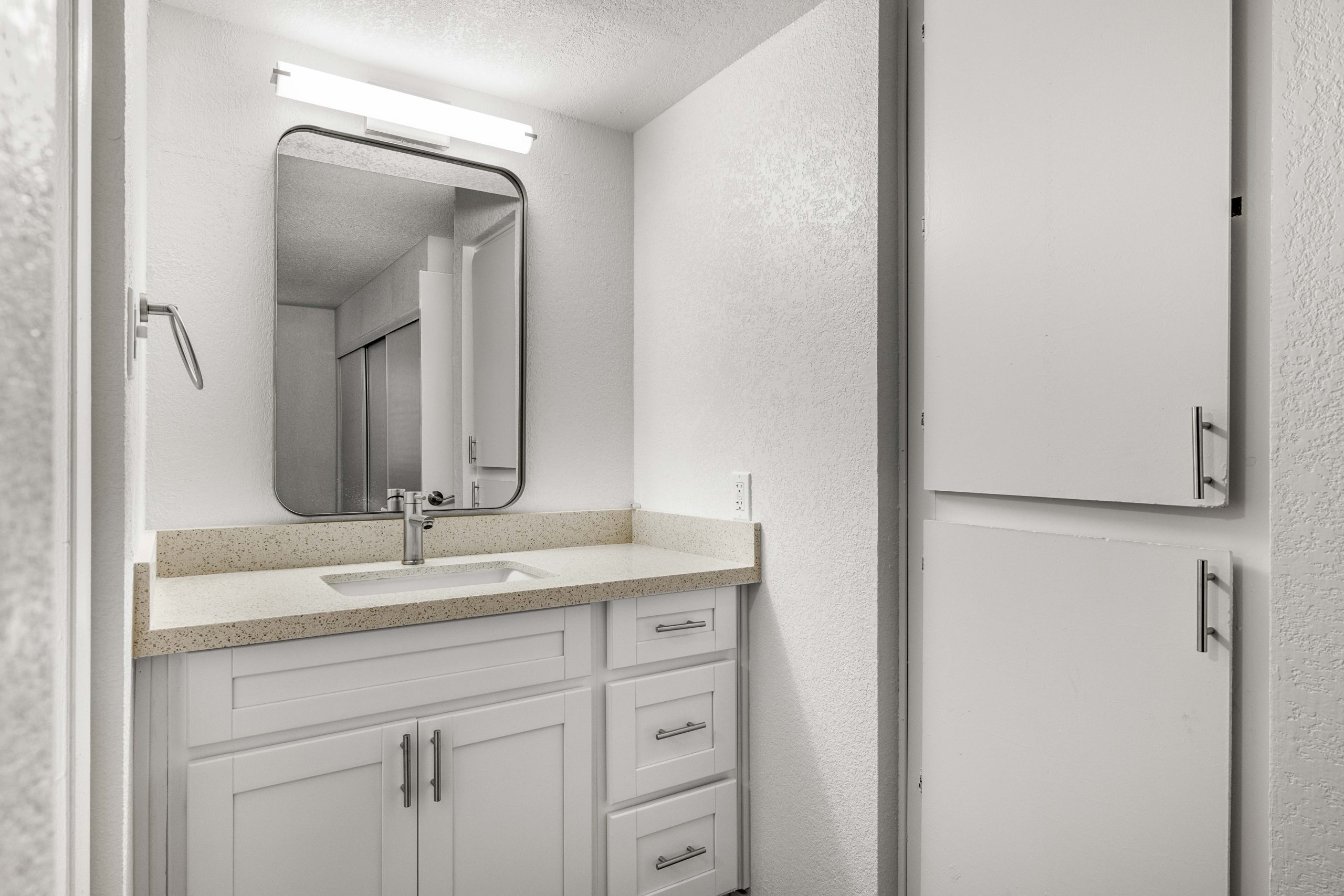 a bathroom with a sink and a cabinet at The Tides on 27th