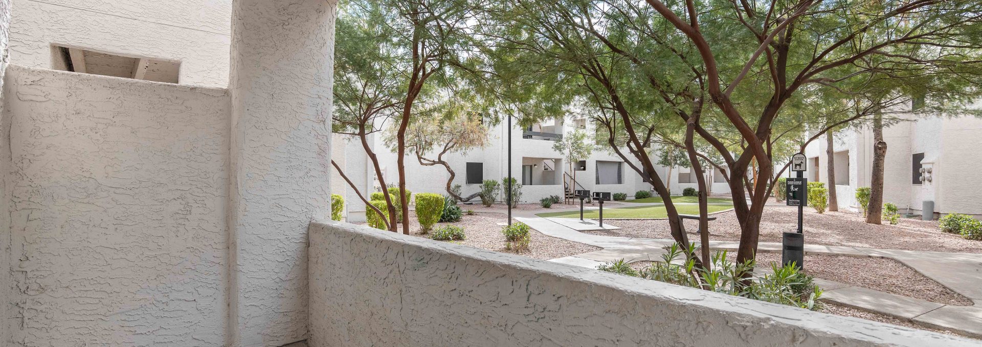 a balcony with a view of trees and a sidewalk at The Tides on 27th