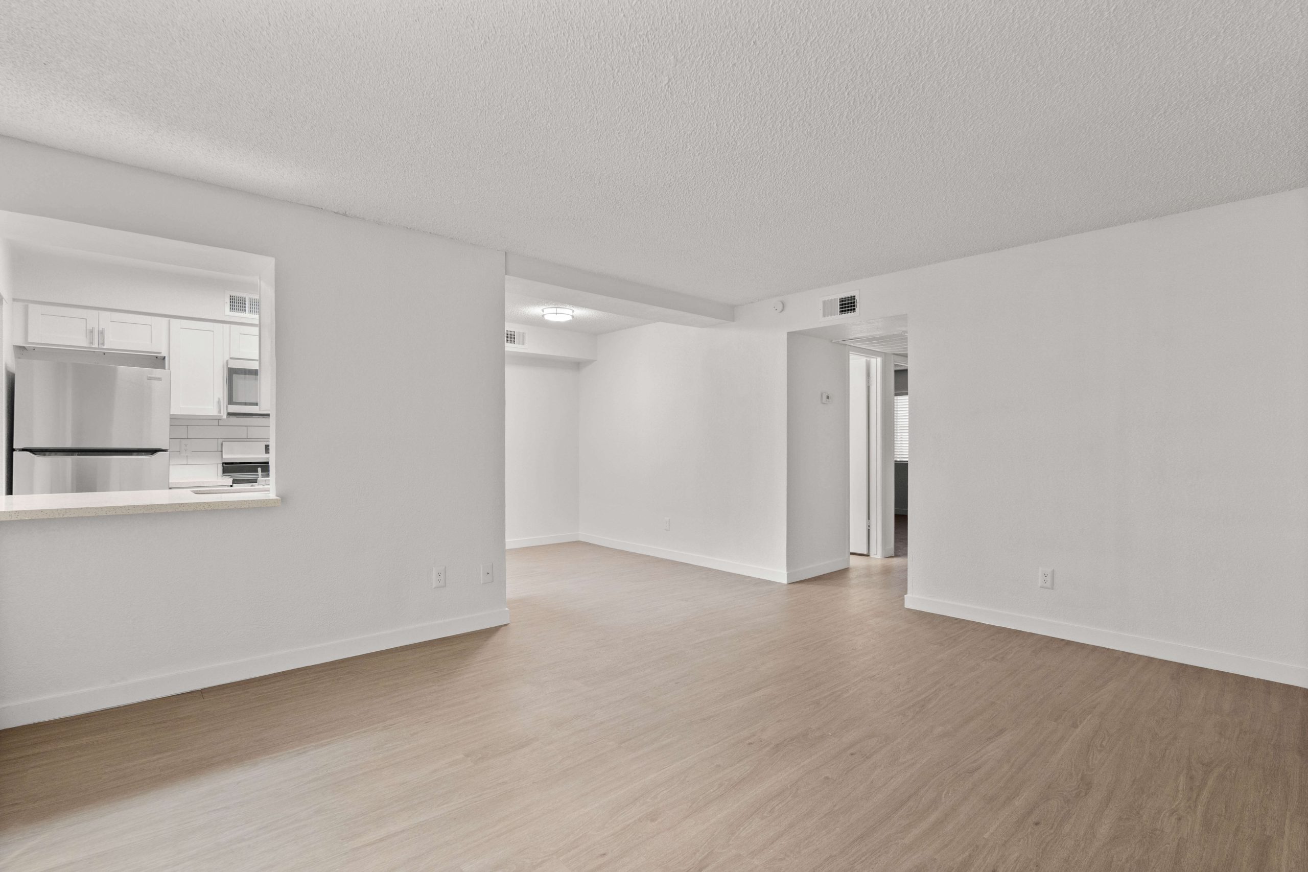 an empty room with hardwood floors and white walls at The Tides on 27th