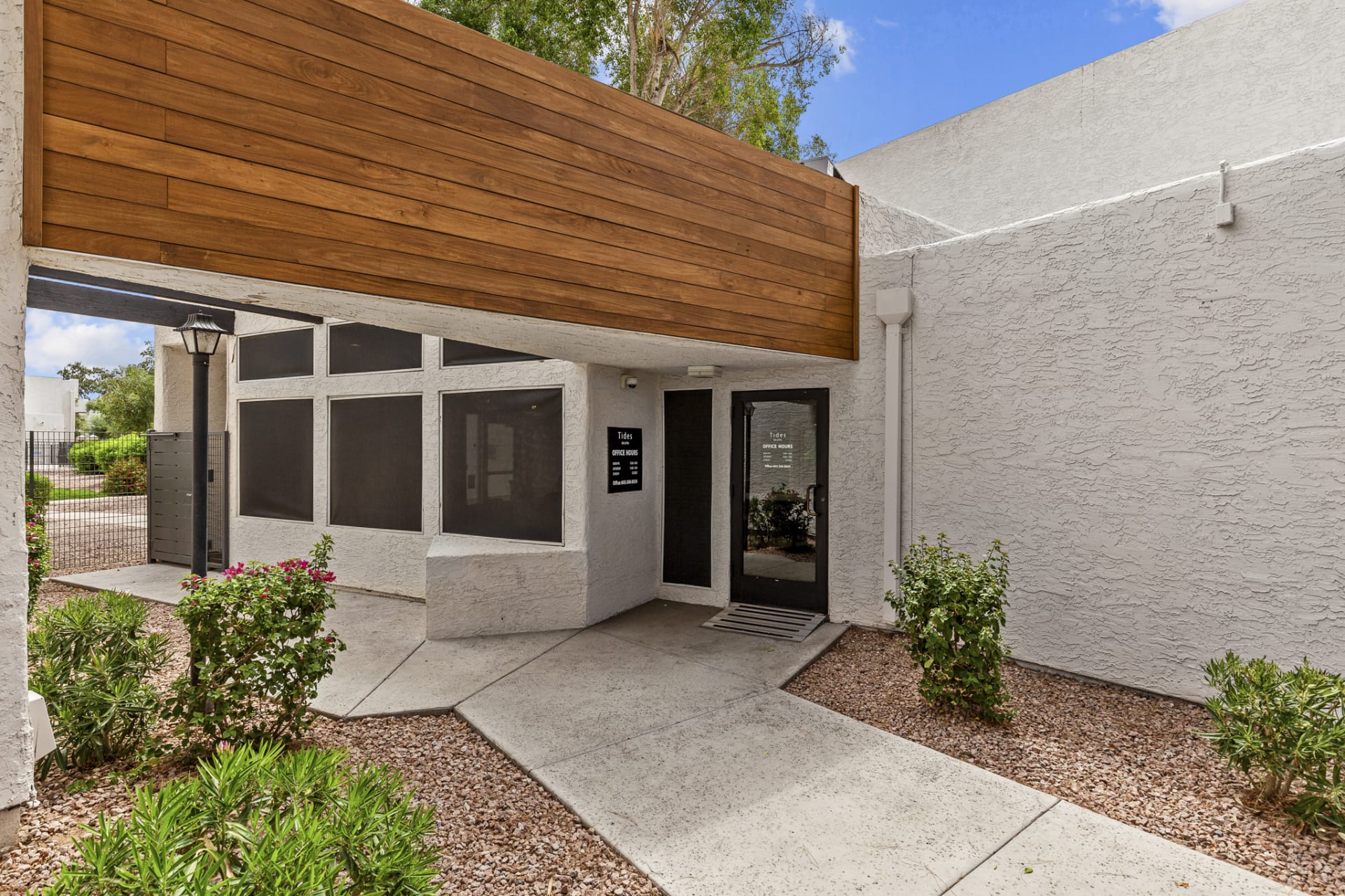 the entrance to a condo building with a wooden door at The Tides on 27th