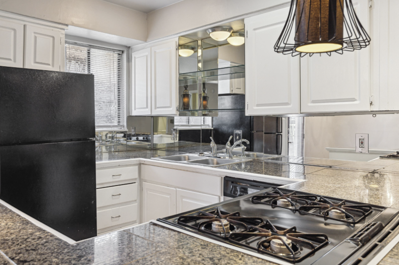 a kitchen with black appliances and white cabinets at The Verandah