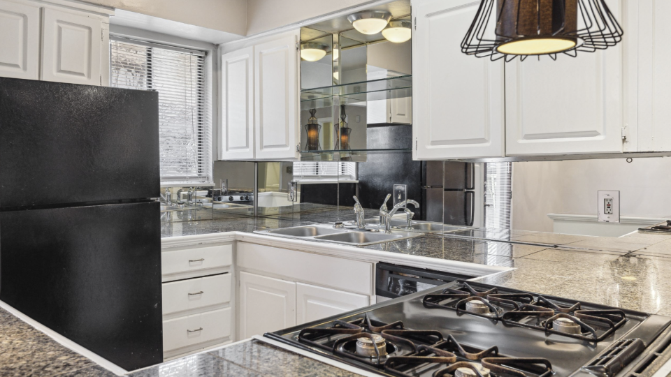 a kitchen with black appliances and white cabinets at The Verandah