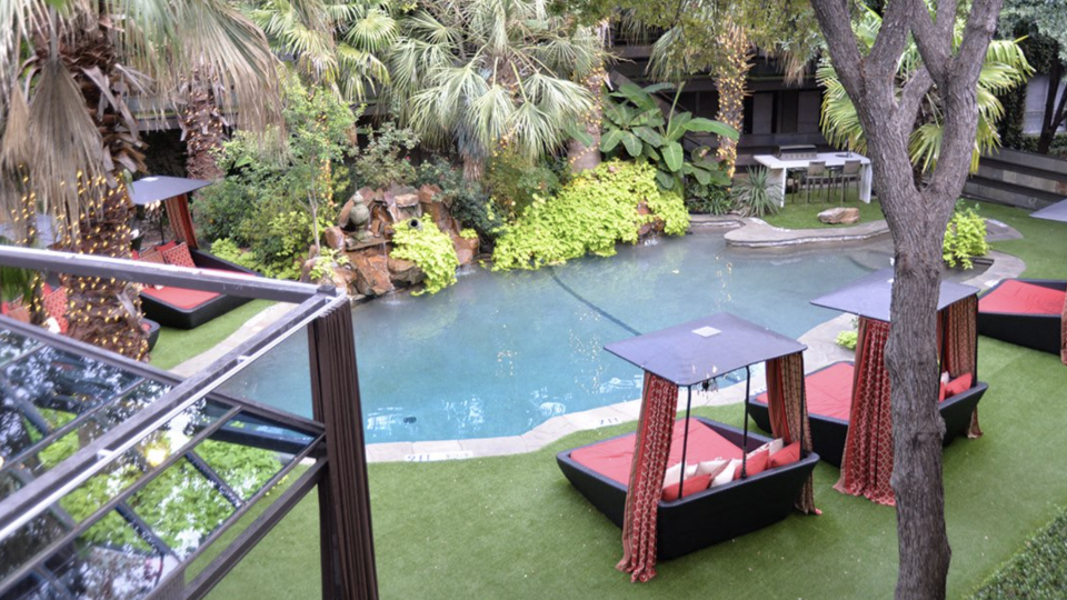 a pool and lounge chairs in a backyard at The Verandah