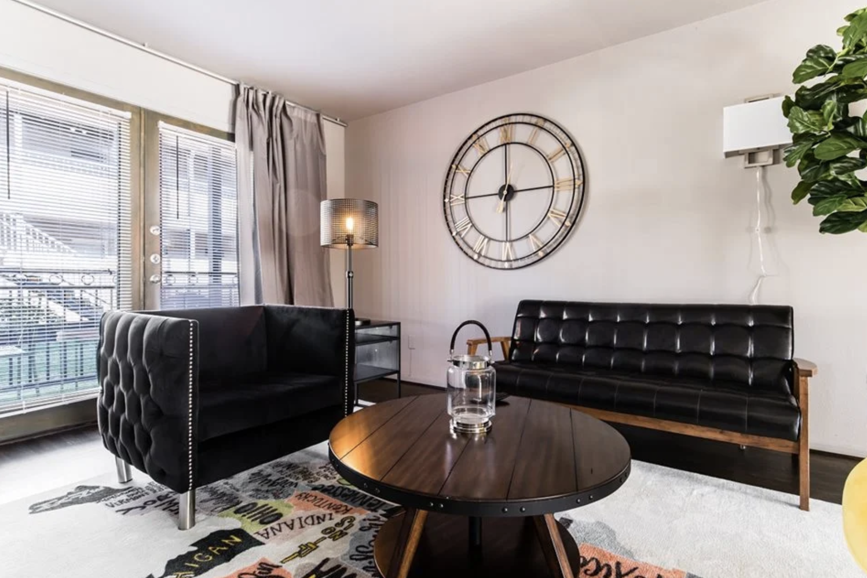 a living room with black furniture and a large clock at The Verandah