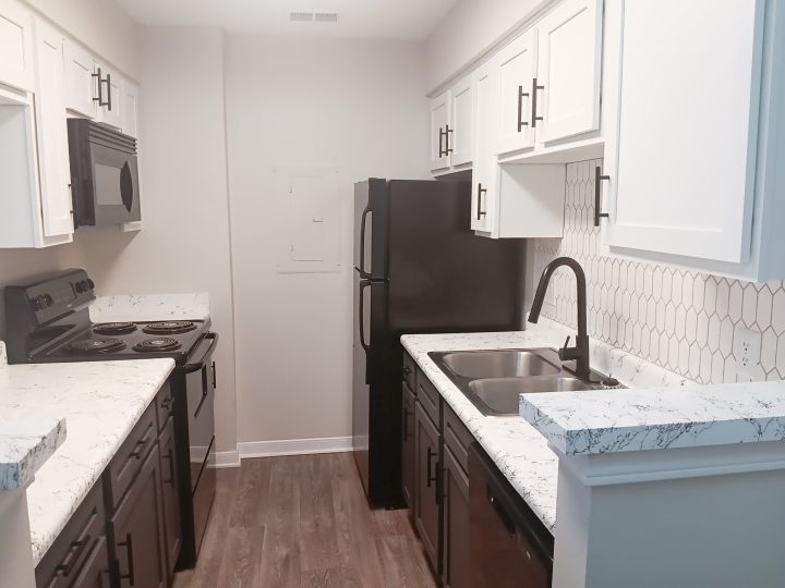 Modern kitchen with black appliances inside an apartment at The Woodlands