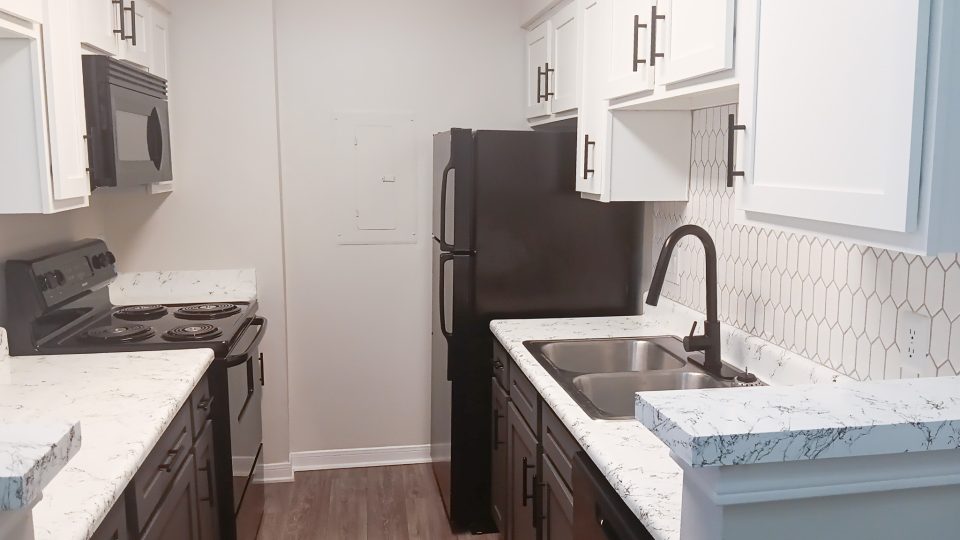 Modern kitchen with black appliances inside an apartment at The Woodlands