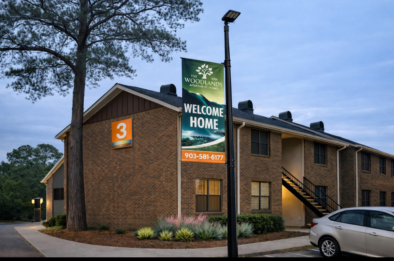 Exterior view of The Woodlands apartment community and parking spots