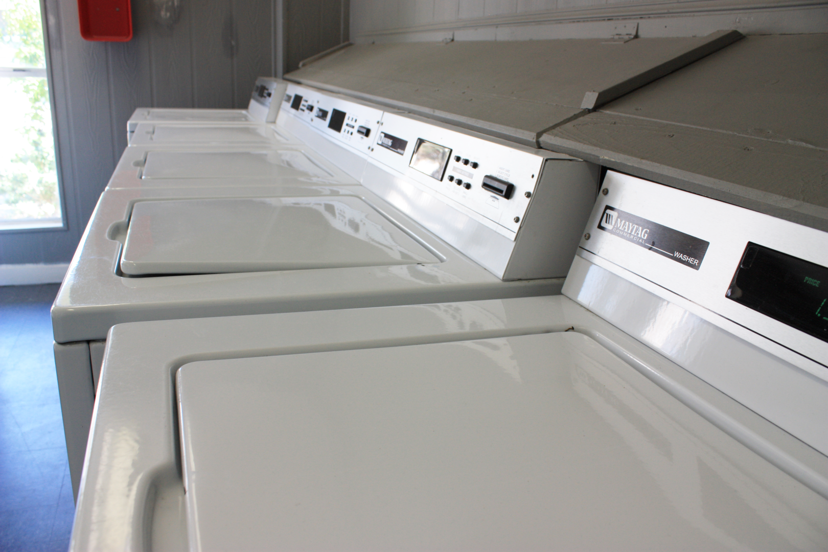 a row of washers and dryers in a laundry room at The Caldera Apartments
