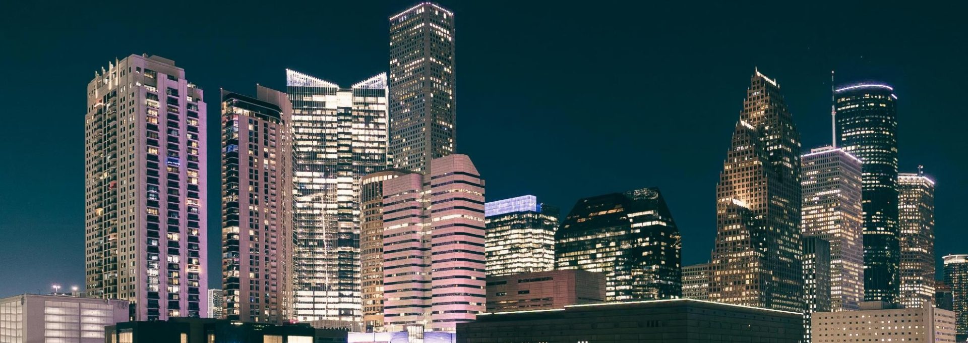 a city at night with tall buildings and skyscrapers