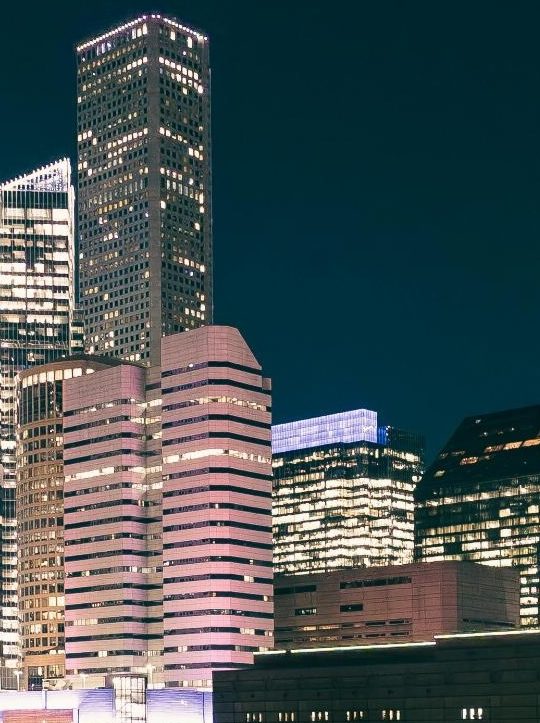 a city at night with tall buildings and skyscrapers