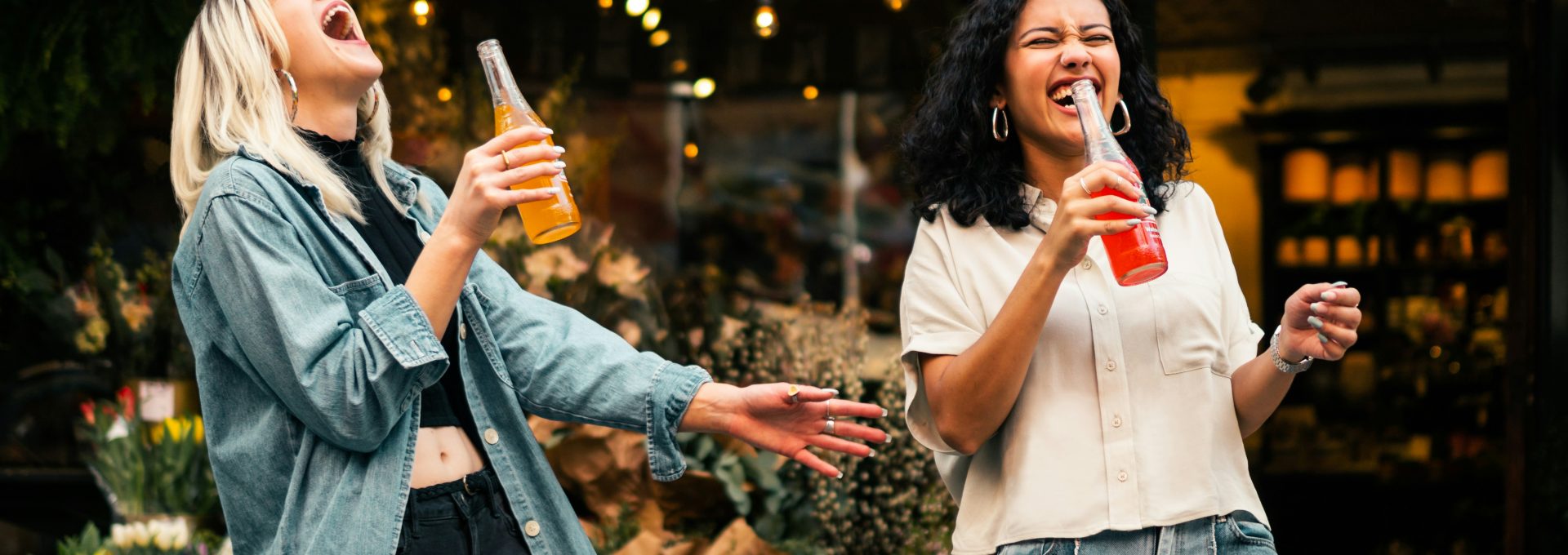 man in blue denim jacket holding clear drinking glass