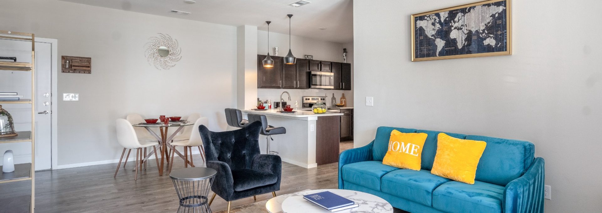 Furnished apartment living room with blue couches and a ceiling fan inside Landmark at Crowley's community