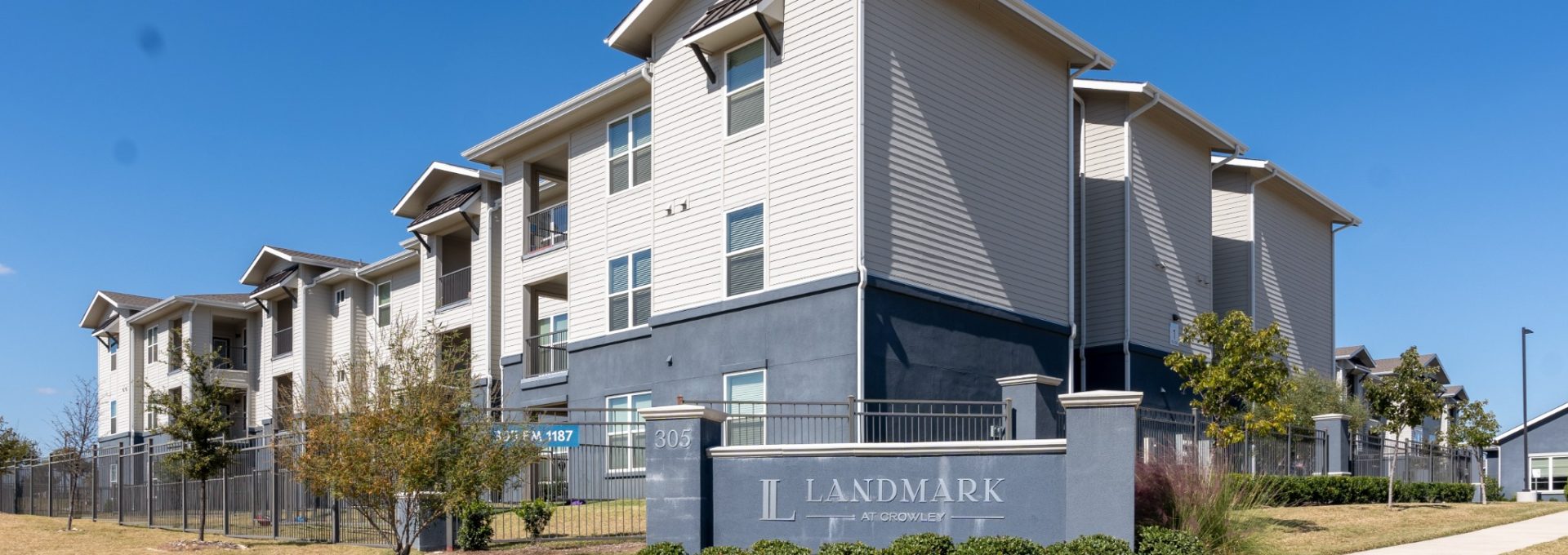 the exterior of an apartment complex with a sign that says, apartment at The Landmark at Crowley