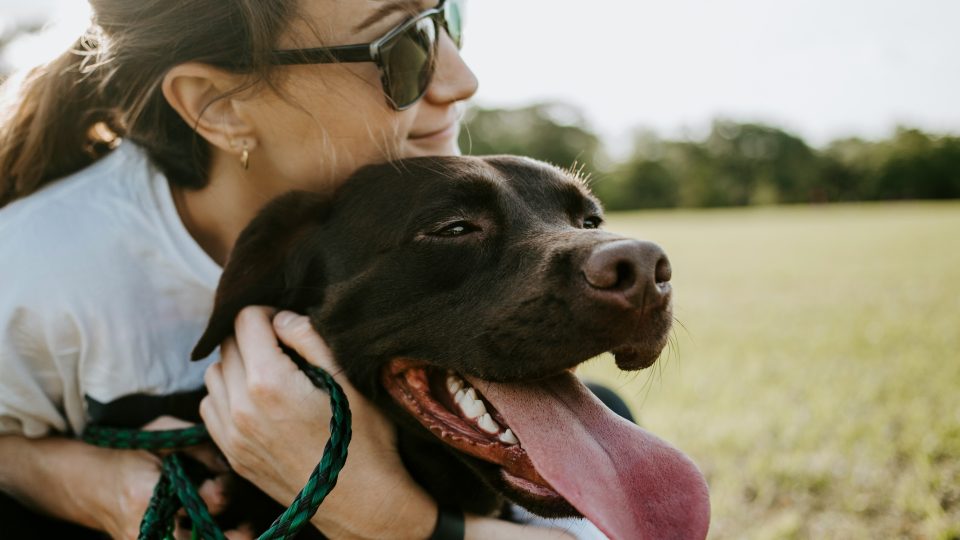 Lifestyle photo of a woman hugging a dog