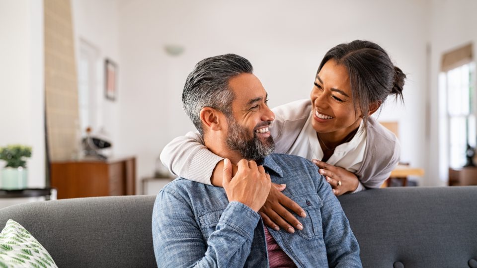a man and woman are sitting on a couch together at The Woodview
