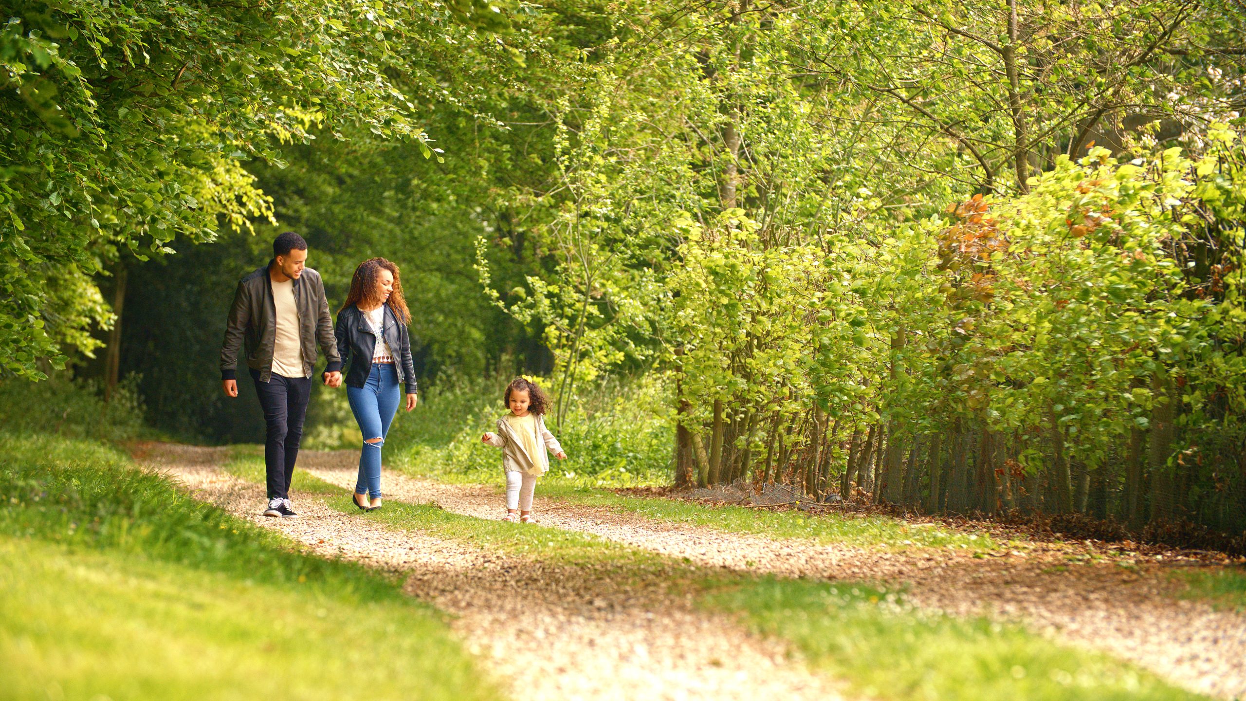 a family walking down a path in the woods at The Woodview