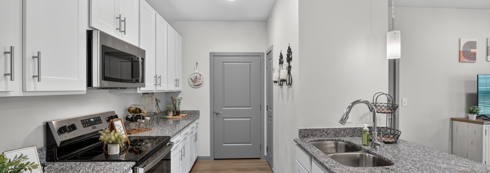 Bright, modern Union Chapel Rd Kitchen with white cabinets, granite counters, stainless steel appliances, wood-look floors.