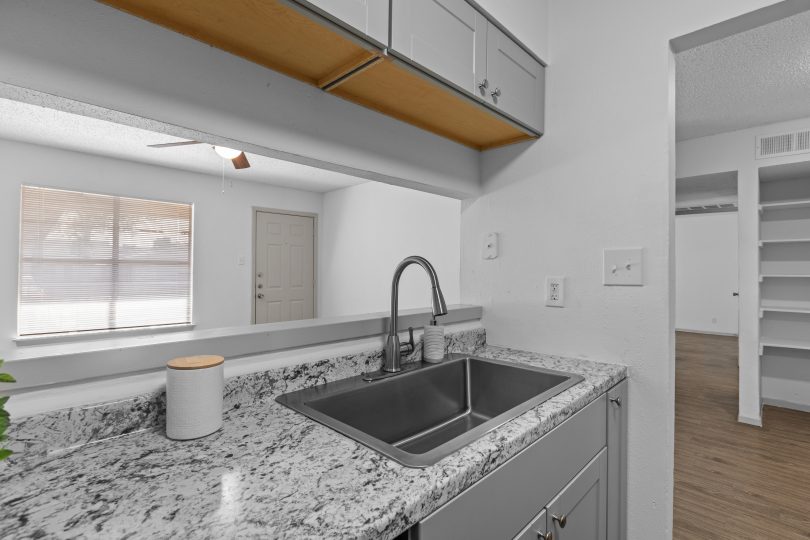 a kitchen with granite counter tops and stainless steel appliances at The Calypso Apartments