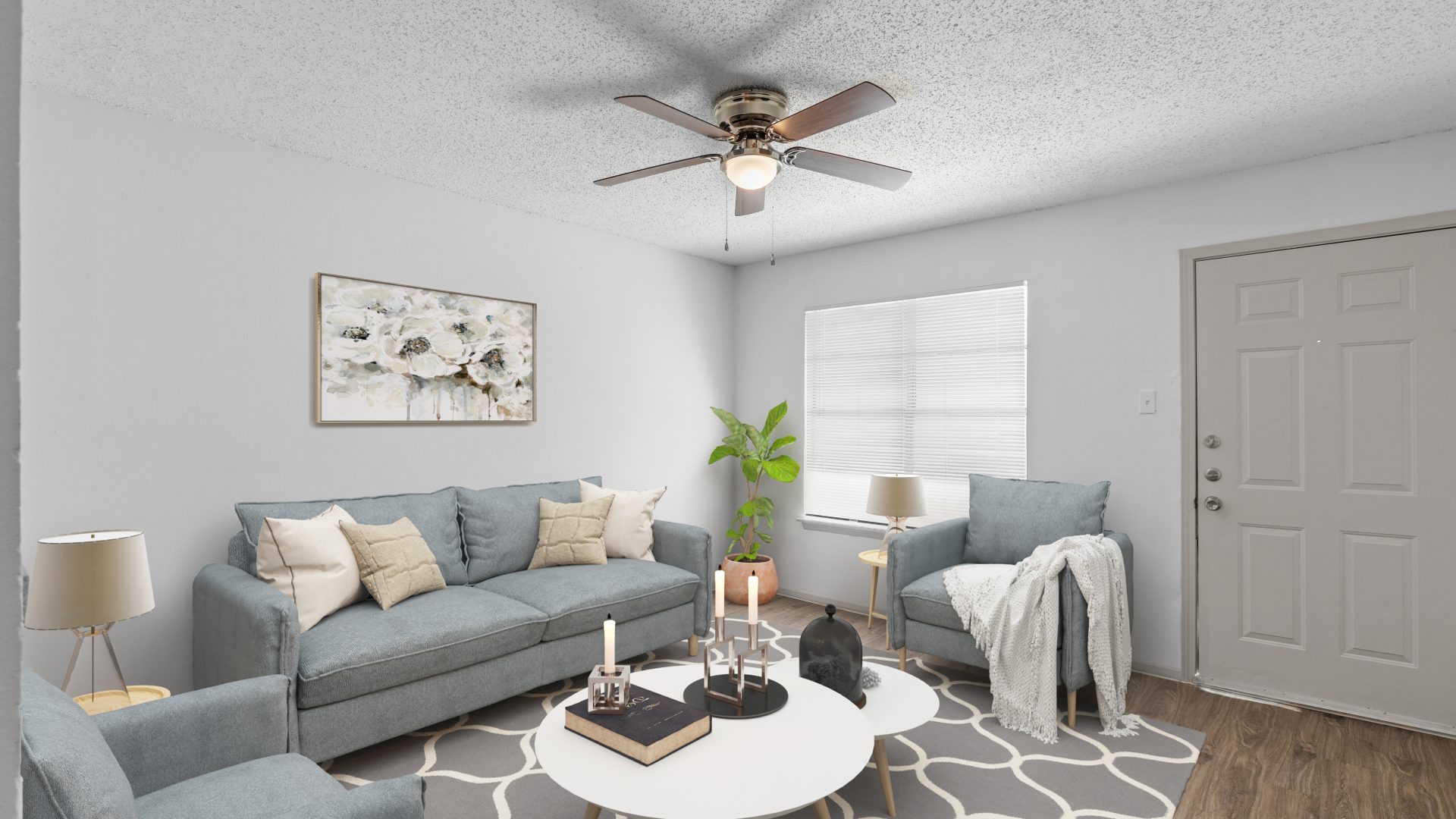 a living room with a ceiling fan and a couch at The Calypso Apartments