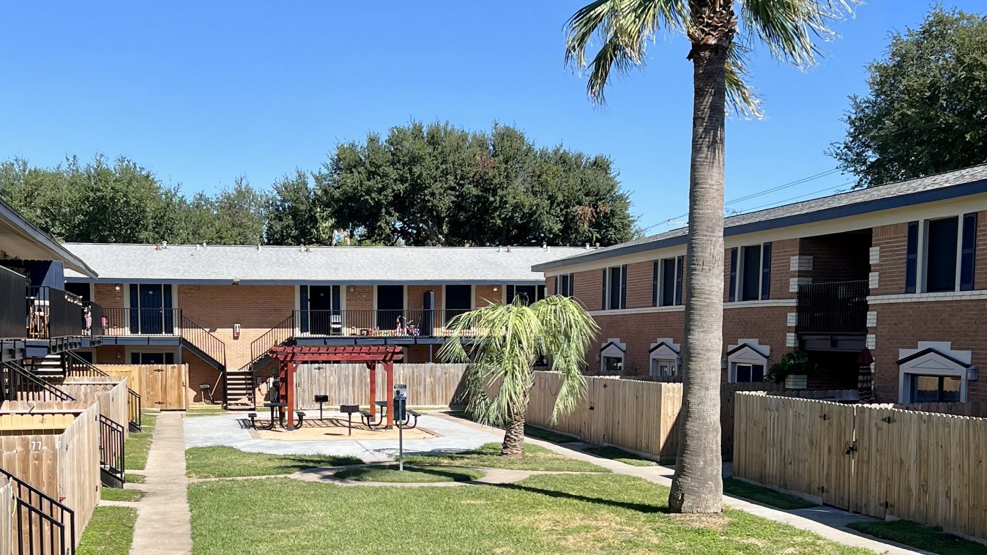 a patio area with a lawn chair and a tennis court
