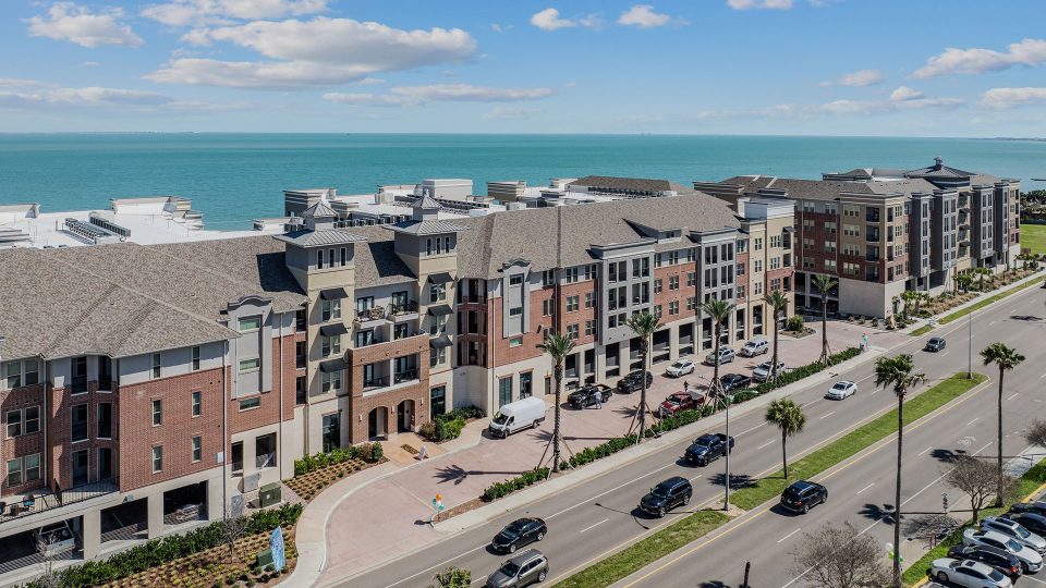 the beach and ocean from an aerial view of a condo building at The Alexa