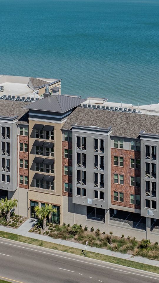 an aerial view of a large apartment complex near the ocean at The Alexa