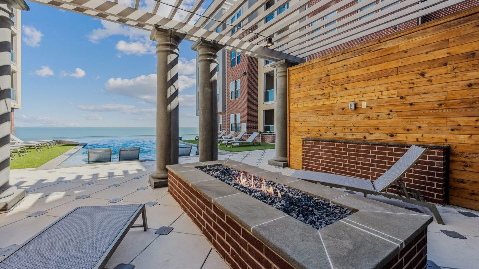 a fire pit on the patio with a view of the ocean at The Alexa