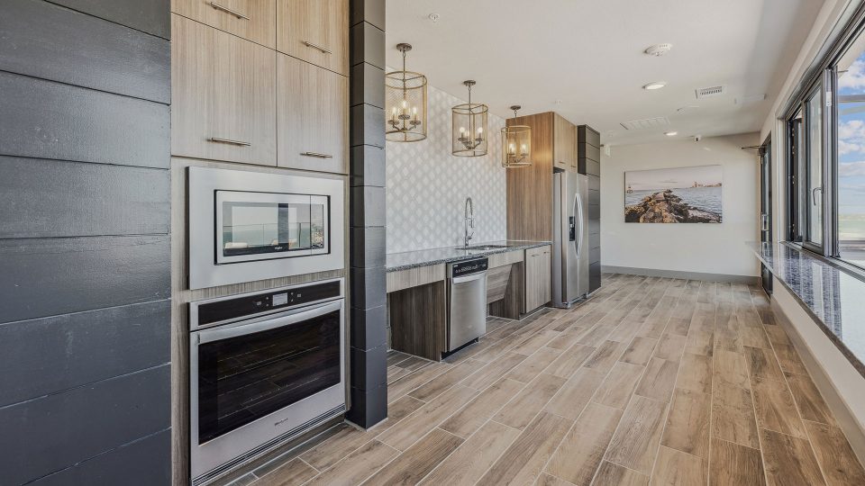 a kitchen with wood floors and stainless steel appliances at The Alexa
