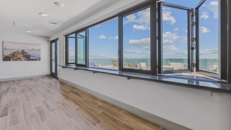 a large room with windows overlooking the ocean at The Alexa
