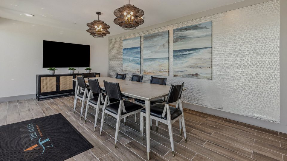 a conference room with a large flat screen tv and a table at The Alexa