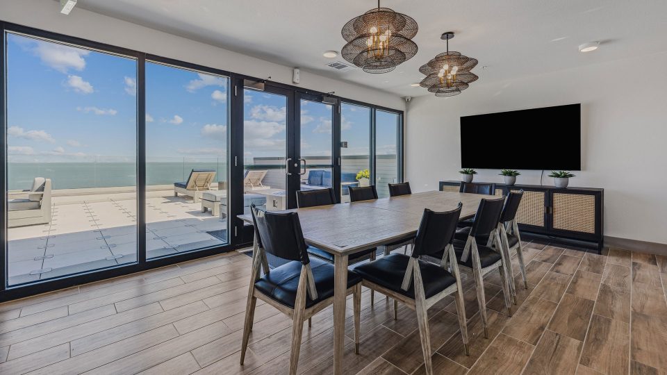 a dining room with a large table and glass doors at The Alexa