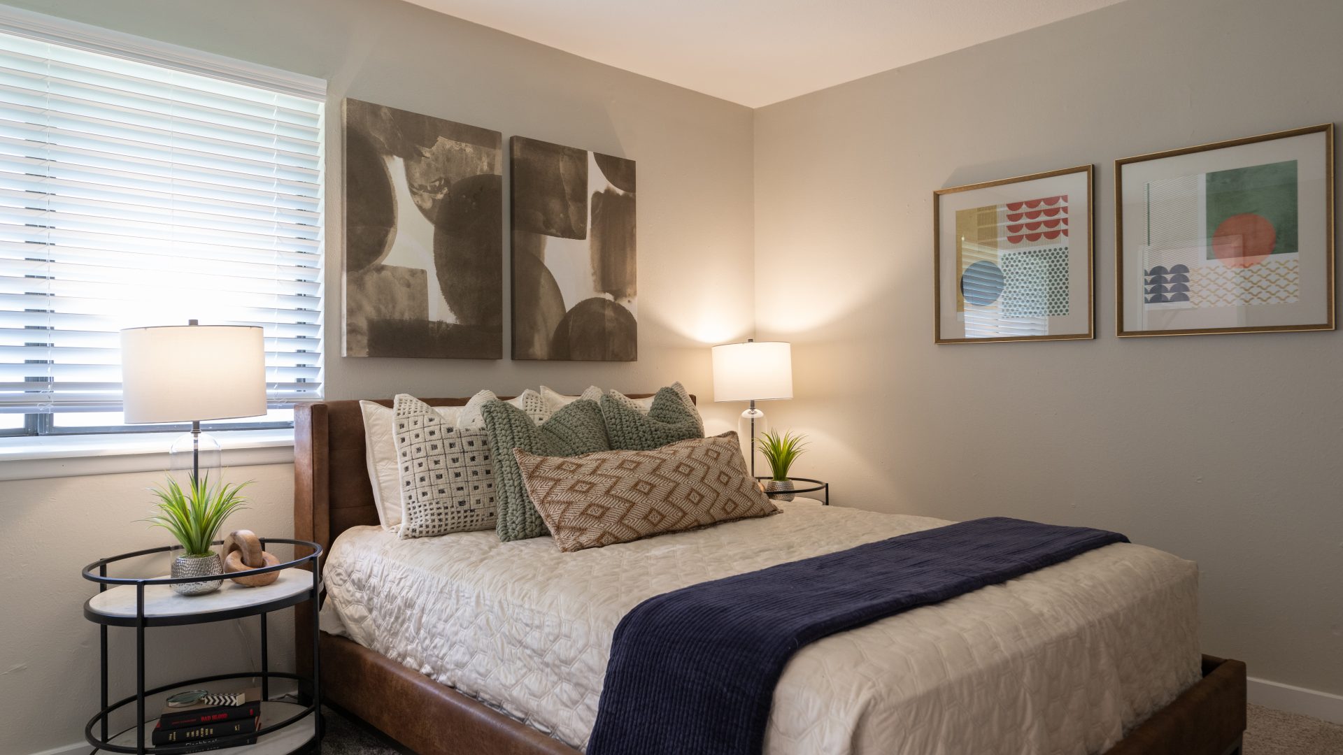 a bedroom with a bed, a desk and a painting on the wall