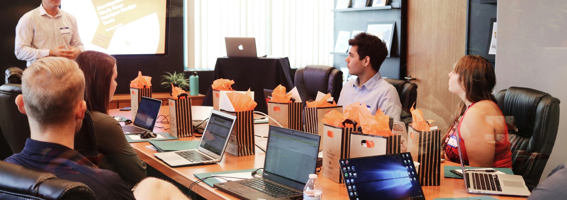 man standing in front of people sitting beside table with laptop computers