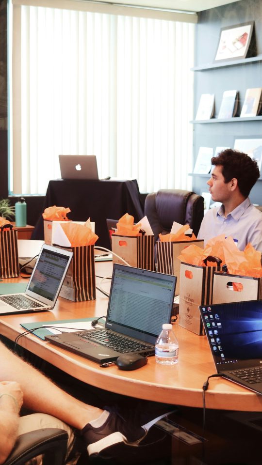 man standing in front of people sitting beside table with laptop computers
