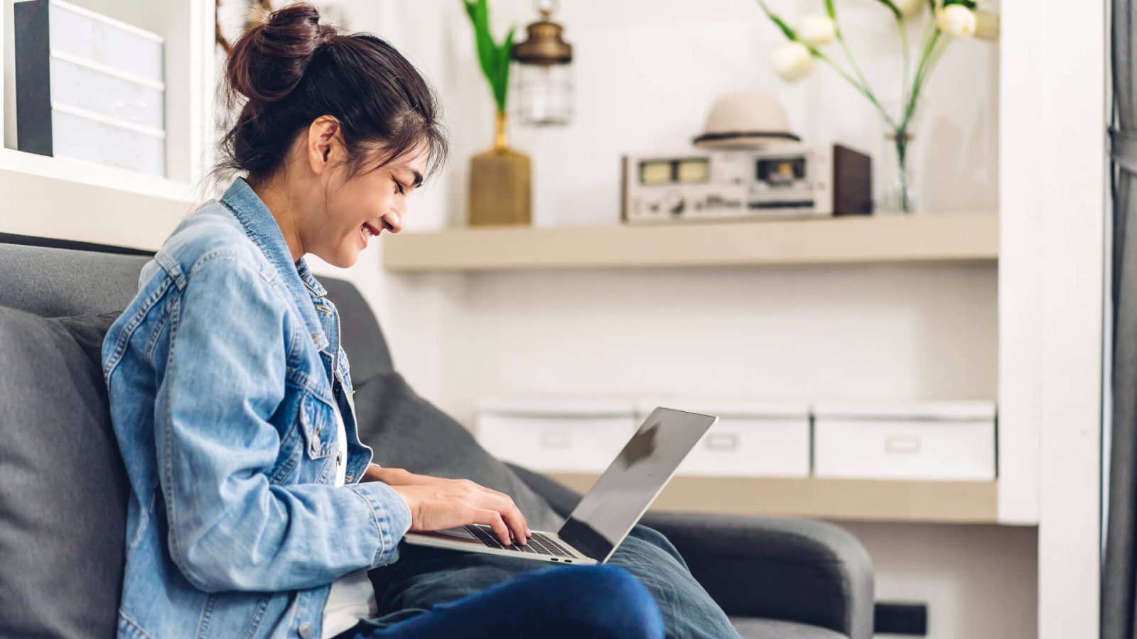 a woman sitting on a couch with a laptop at The  Apiary