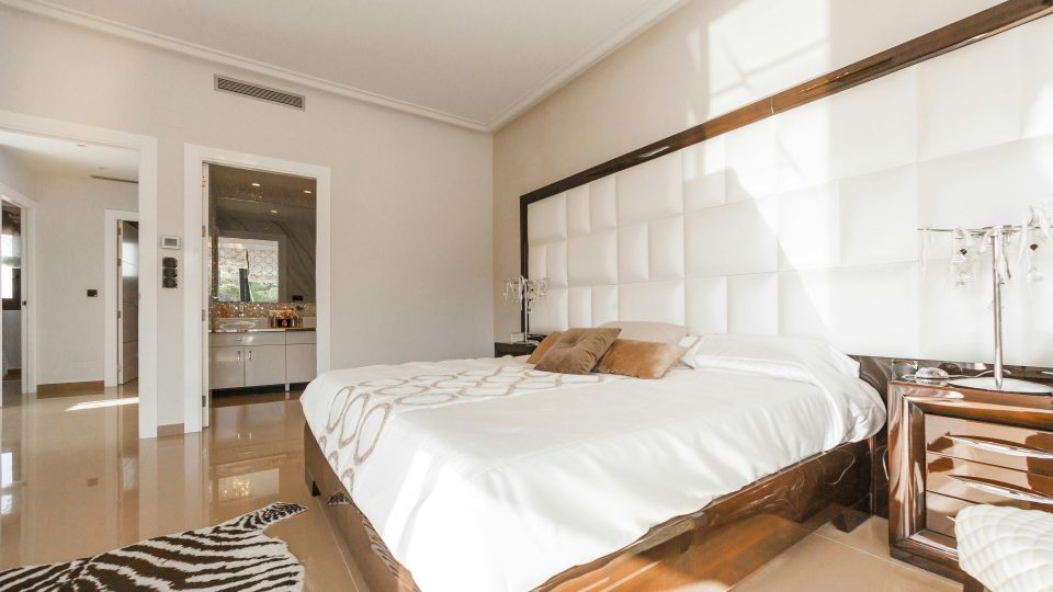 brown wooden bed frame with white cover beside brown wooden nightstand