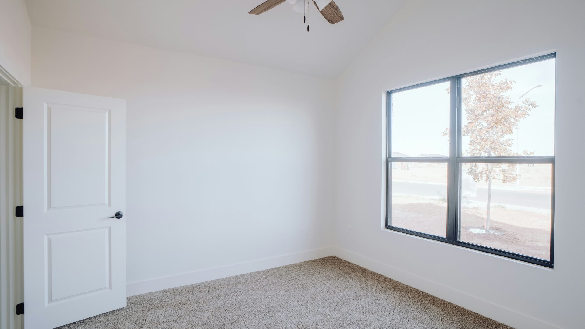 an empty room with a ceiling fan and a window