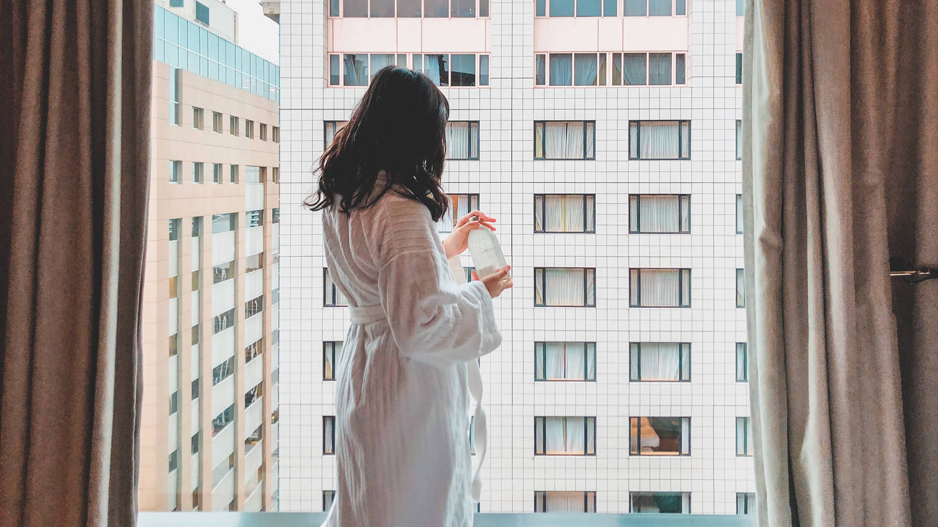 A woman standing near the window
