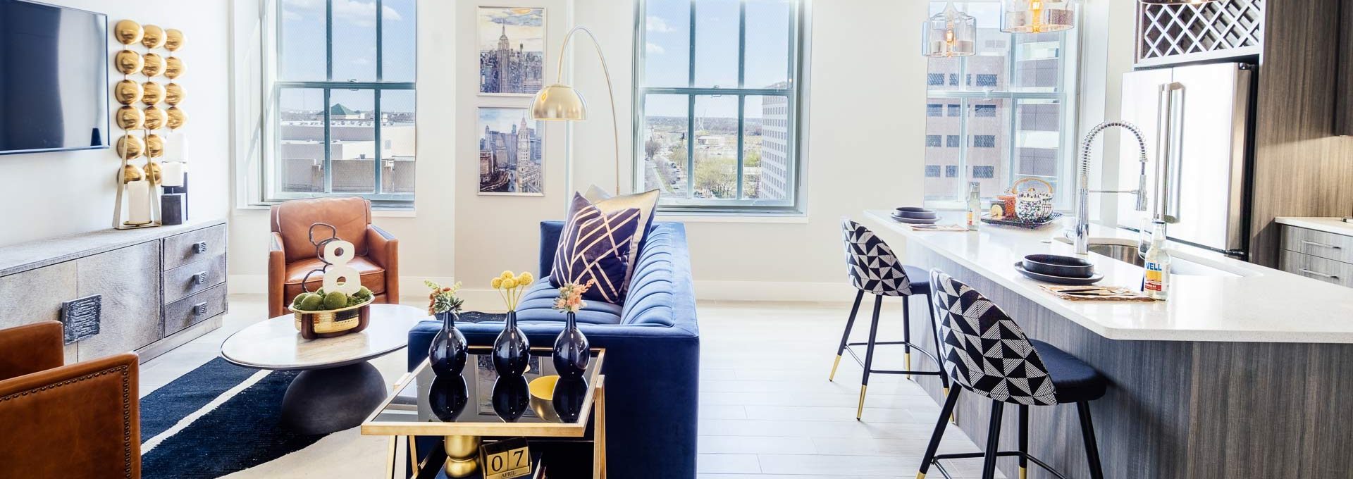 a living room with a blue couch and a white table at The  First