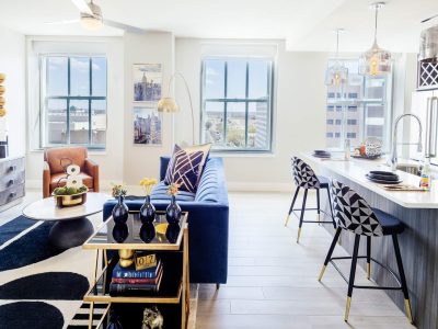 a living room with a blue couch and a white table at The  First
