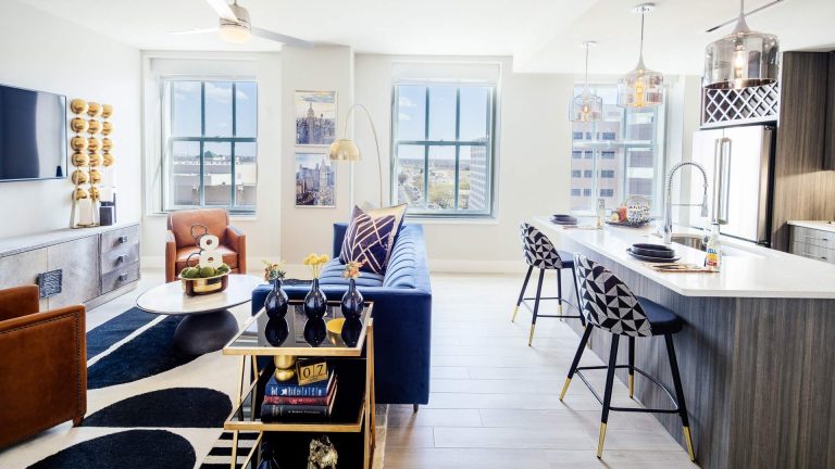 a living room with a blue couch and a white table at The  First