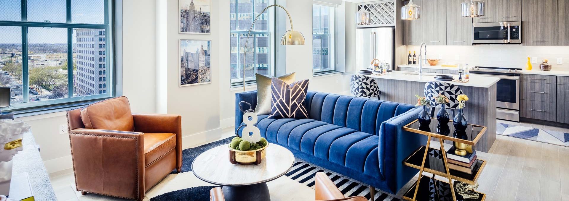 a living room with blue furniture and a large window at The  First