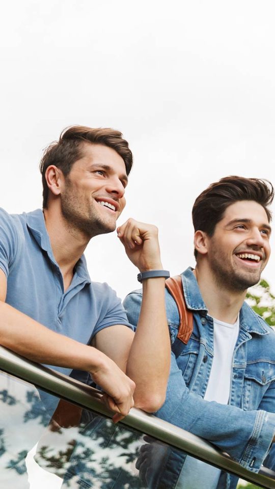 Two happy friends standing in the balcony